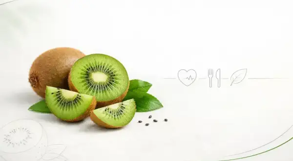 Całe i pokrojone kiwi z liśćmi, symbolizujące, czy kiwi jest zdrowe. Obok ikony serca, sztućców i liścia.