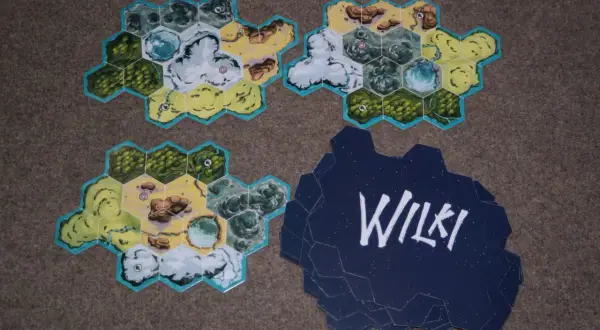 Karty do gry planszowej "Wilki" przedstawiające fragmenty krajobrazu: lasy, góry, wodę i pustynię.