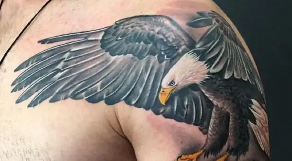Tatuaż białego orła z rozpostartymi skrzydłami na ramieniu.
