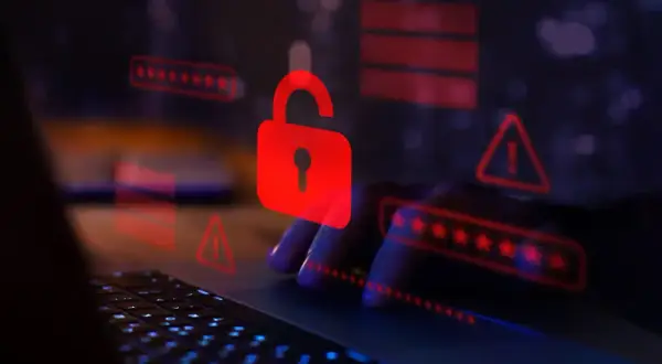 Czerwona kłódka i ostrzeżenia na ekranie laptopa symbolizują zagrożenie. Uważaj na spear phishing, który może prowadzić do wycieku danych.