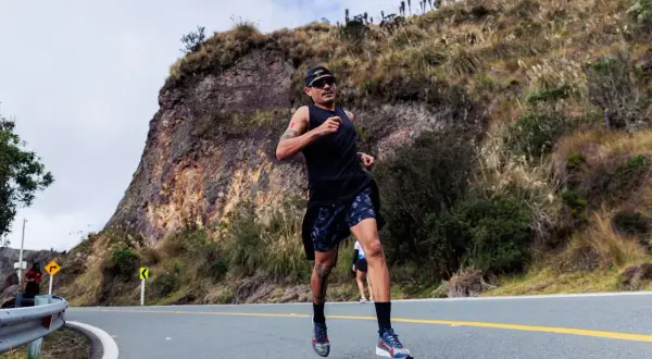 Mężczyzna biegnie pod górę, pokonując trasę biegu na 10 km. Jaki czas jest dobry? Zależy od kondycji, ale ten zawodnik wygląda na zdeterminowanego.