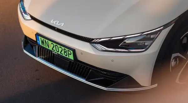 Przód samochodu Kia z zieloną tablicą rejestracyjną WN 2028P.