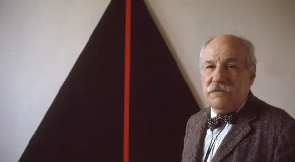 John Plaster poses in front of a striking abstract painting, possibly at the Guggenheim.