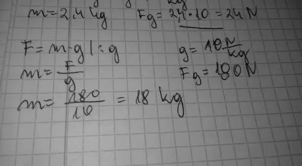 Ręcznie pisane wzory fizyczne na kratkowanym papierze, w tym F=m*g i obliczenia.