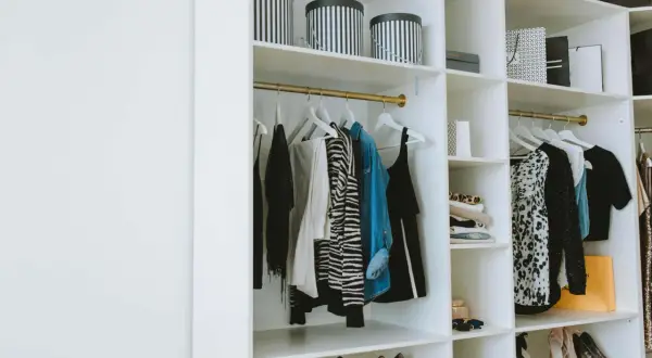 Estanterías armario con ropa colgada, cajas y zapatos organizados.