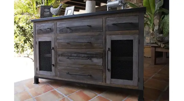 Buffet en bois vieilli, prêt à se relooker. Ses tiroirs et portes grillagées lui donnent un style industriel unique.