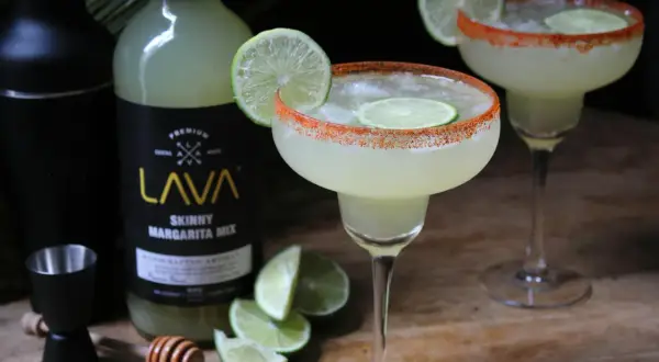 Idealny margarita przepis z mixem LAVA. Dwa drinki z solą i limonką, shaker, miarka i plasterki limonki.