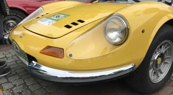 Żółte Ferrari Dino z numerem 56 na naklejce, błyszczące chromem, gotowe do rajdu.