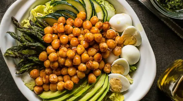 Ensalada de garbanzos con espárragos, aguacate, huevo duro y calabacín. Ingredientes frescos y saludables.