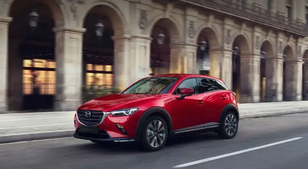 Czerwona Mazda CX-3 w ruchu miejskim. Wiele osób szuka mazda cx-3 opinie, by poznać ten stylowy crossover.