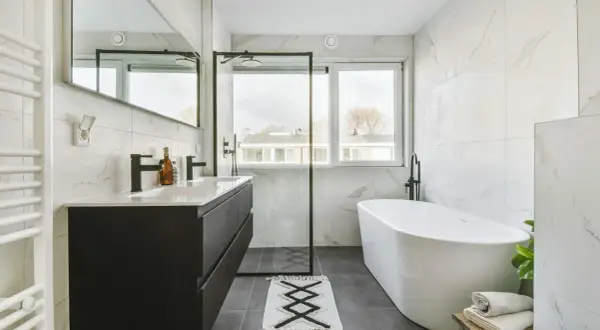 Nowoczesna łazienka z wanną i prysznicem. Okno w kabinie prysznicowej można zabezpieczyć, montując na nim specjalną folię lub roletę.