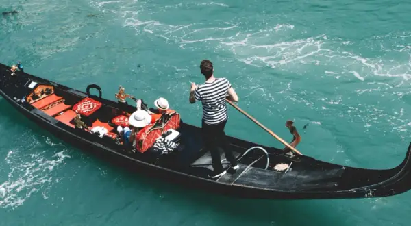 Gondola w Wenecji z pasażerami i gondolierem. Zastanawiasz się, ile kosztuje gondola w Wenecji?