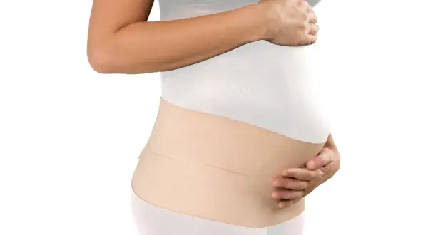 Mujer embarazada con una faja postparto de color beige, que brinda soporte y comodidad.