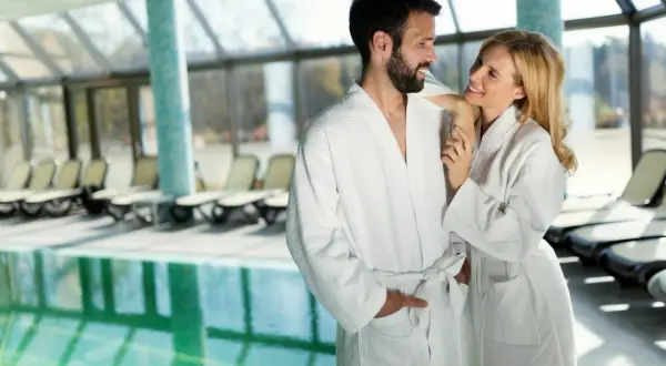 Para w szlafrokach przy basenie w spa.