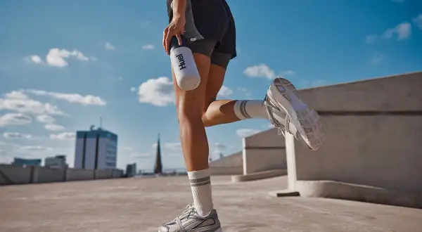 Läuferin mit Huel-Flasche, die auf dem Weg zu 10000 Schritten am Tag ist.