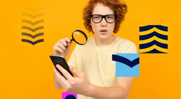 Chłopiec z rudymi włosami i okularami trzyma lupę i smartfon na pomarańczowym tle z geometrycznymi kształtami.