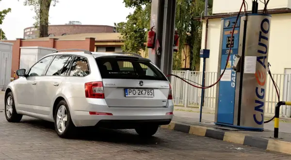 Srebrne kombi Skoda Octavia tankuje gaz LPG propan-butan na stacji paliw.