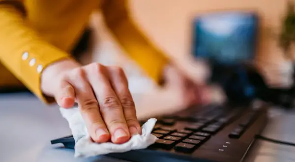 En hand torkar av ett tangentbord med en våtservett. Kanske ett tecken på kontrollbehov, diagnos ställs inte här.
