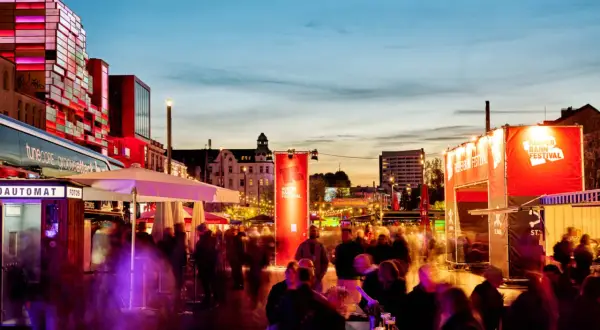 Menschenmassen beleben die Reeperbahn in der Woche, während das Reeperbahn Festival mit roten Bannern und Lichtern für Stimmung sorgt.