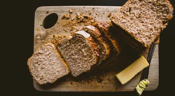 Kromka chleba pełnoziarnistego z margaryną na cholesterol.