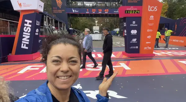 La finisher sorride alla telecamera vicino al traguardo della maratona New York.