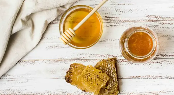 Miód w słoiku i miseczce, plastry miodu. Czy miód to substytut? Nie, to naturalny słodki produkt.