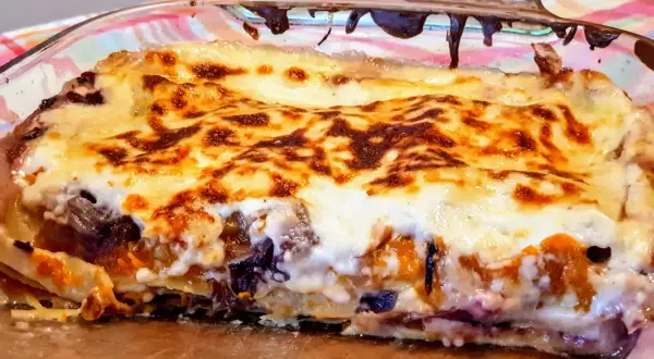Lasagne con zucca e scamorza, dorate e filanti, in una teglia di vetro. Un piatto autunnale irresistibile.