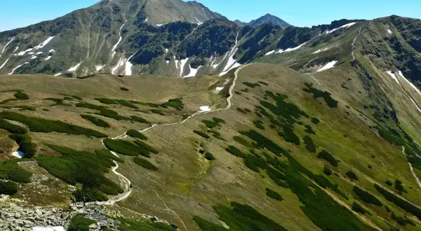 Wędrówka po skalistych graniach Tatr, gdzie ścieżki wiją się wśród kosodrzewin i resztek śniegu. To jedne z najtrudniejszych szlaków w Tatrach.
