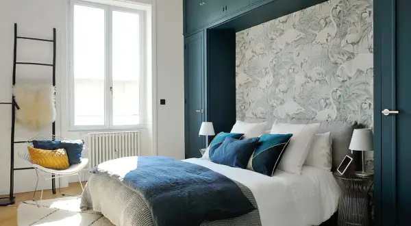 Chambre adulte aux tons bleus profonds et papier peint flamants roses. Une peinture chambre adulte 2 couleurs qui invite à la détente.