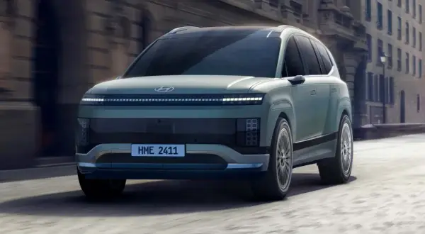 Przyszłościowy Hyundai Ioniq 9 w kolorze miętowym, poruszający się po miejskiej ulicy.
