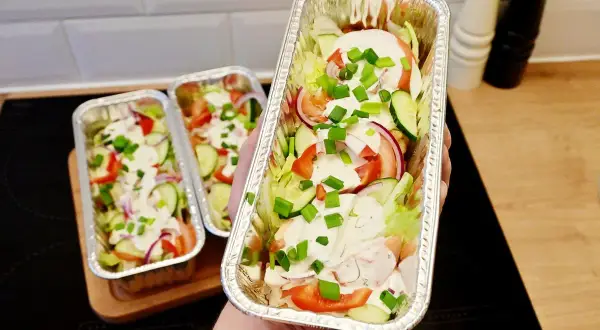 Pyszny kebab holenderski w aluminiowych tackach, pełen świeżych warzyw i sosu. Idealny na wynos!