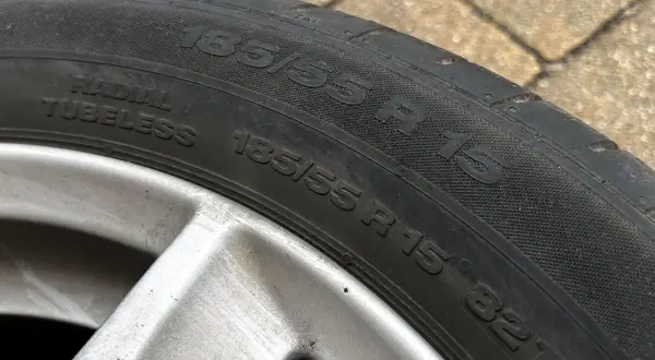 Oznaczenia opon: 185/55 R 15 82T. Widoczna felga aluminiowa.