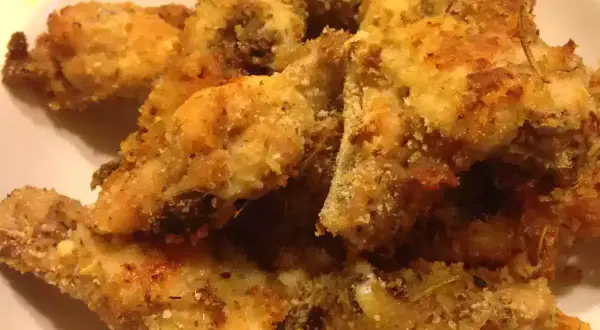 Croccante pollo alla diavola impanato e cotto al forno, con erbe aromatiche.