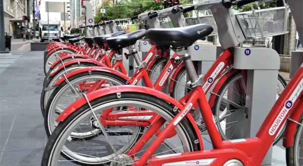 Rzędy czerwonych rowerów miejskich Houston B-cycle, gotowych do wypożyczenia. To świetny przykład **saas** w transporcie miejskim.