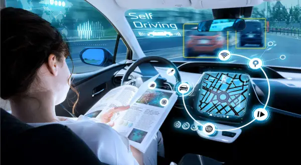 Donna legge un libro mentre l'auto guida da sola, mostrando la tecnologia di guida autonoma livello 4.