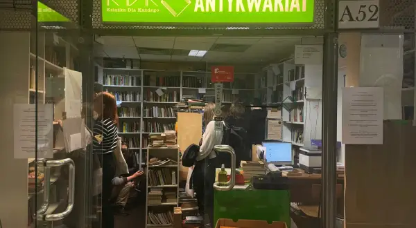 W antykwariacie "Książka Dla Każdego" panuje atmosfera cmentarz zapomnianych książek. Wnętrze pełne regałów z literaturą, gdzie ludzie przeglądają stare tomy.