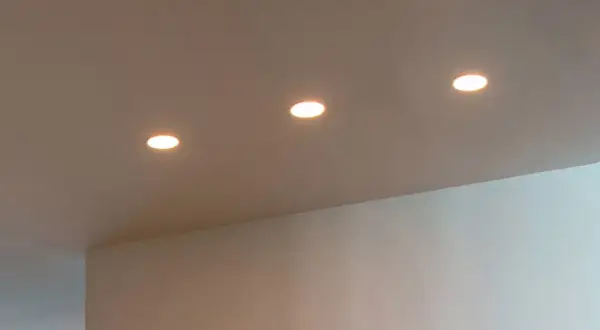 Trois spots encastrés éclairent un plafond. La lampe LED offre des avantages, mais il faut aussi considérer ses inconvénients.
