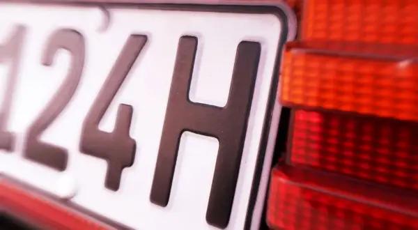 Nahaufnahme eines Nummernschilds mit der Aufschrift "124H". Die rote Rückleuchte des Autos ist daneben zu sehen. Hoffentlich gibt es keine 07-Kennzeichen-Strafe.