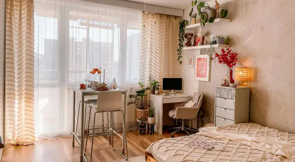Idee per arredare una casa piccola: un angolo studio, un tavolo alto per mangiare e un letto accogliente, tutto in uno spazio compatto.