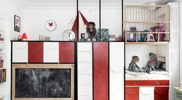 Zwei Kinder teilen sich ein kreatives Zimmer mit Hochbetten und Tafel.