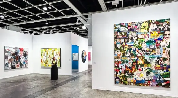 A vibrant collage artwork dominates the wall at Art Basel, showcasing a diverse collection of images.