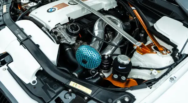 Motor tuning en un BMW: filtro de aire azul, intercooler cromado y refuerzo naranja.