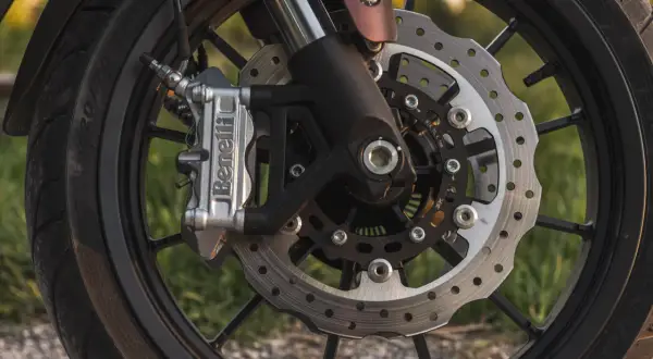 Zbliżenie na tarczę hamulcową motocykla z zaciskiem Benelli.