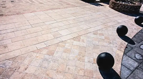 Pavimentazione esterna con eleganti mattonelle in pietra lavica, disposte in motivi geometrici che creano un suggestivo gioco di luci e ombre.