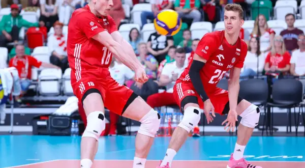 Dwóch siatkarzy w czerwonych strojach walczy o piłkę. Jeden z nich, numer 16, przyjmuje zagrywkę, drugi, numer 25, czeka na dalszy rozwój akcji. Zielona kartka w siatkówce nie istnieje, ale ta akcja jest warta złota!