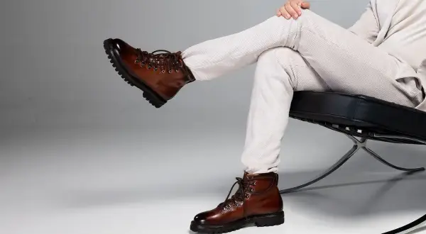 Scarponcini stringati in pelle marrone lucida, un classico per un look **oxs uomo** elegante e avventuroso.