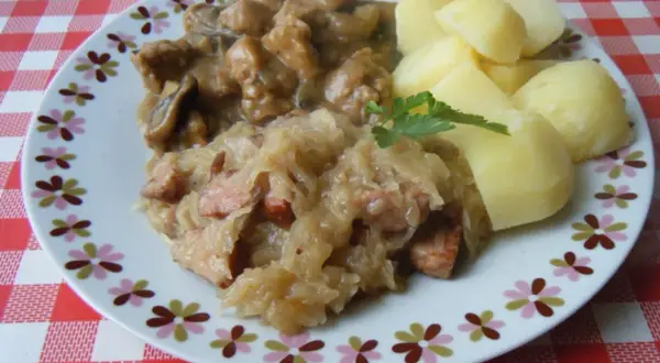 Pyszna kapusta kiszona gotowana z kawałkami mięsa i kiełbasy, podana z ziemniakami.