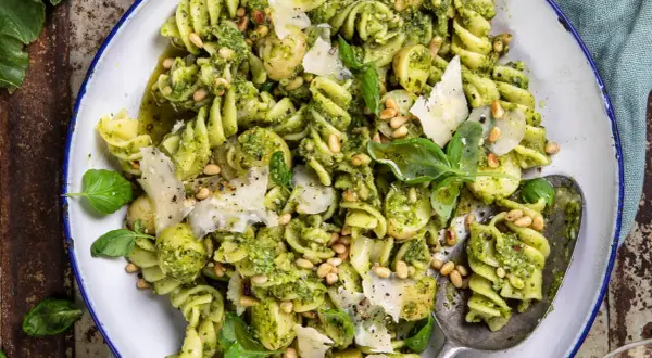 En närbild på en härlig pastasallad med pesto, pinjenötter och parmesan. Perfekt för en snabb och smakrik lunch.