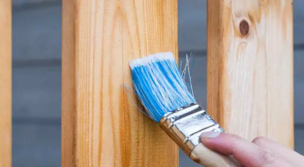 Pennello blu applica una finitura trasparente per riportare il legno al naturale, esaltandone le venature.