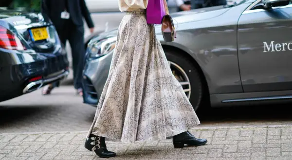 Eleganckie stylizacje ze spódnicą: zwiewna, wzorzysta spódnica maxi i botki z klamrami.